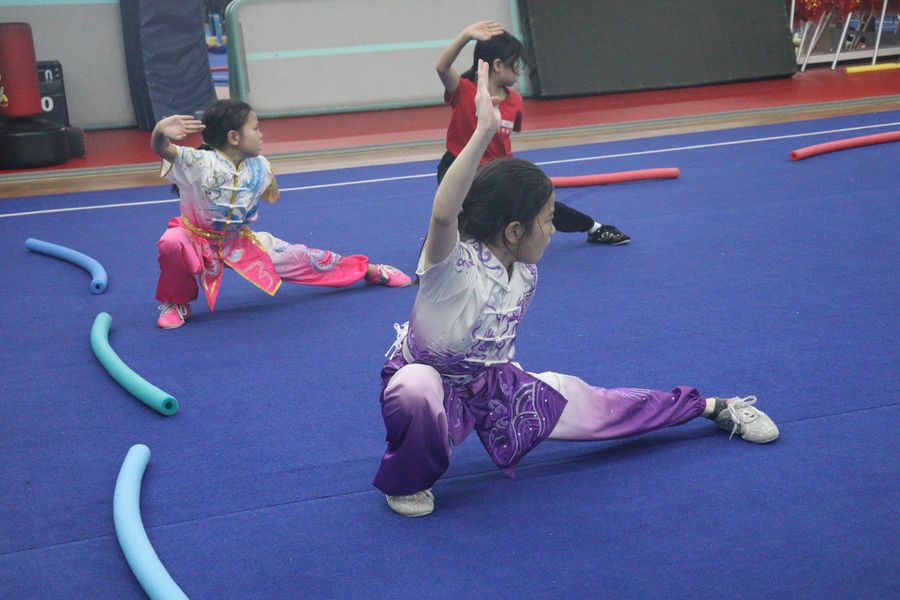 Two students holding matching low stances