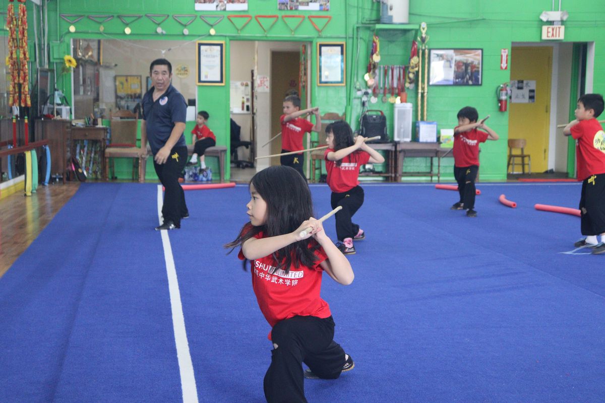 A young student practising with a training weapon