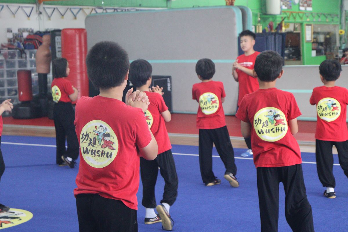 Students training in the hall beside the heavy bags