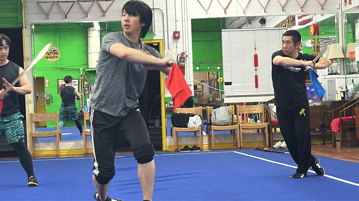 Two adults training with weapons