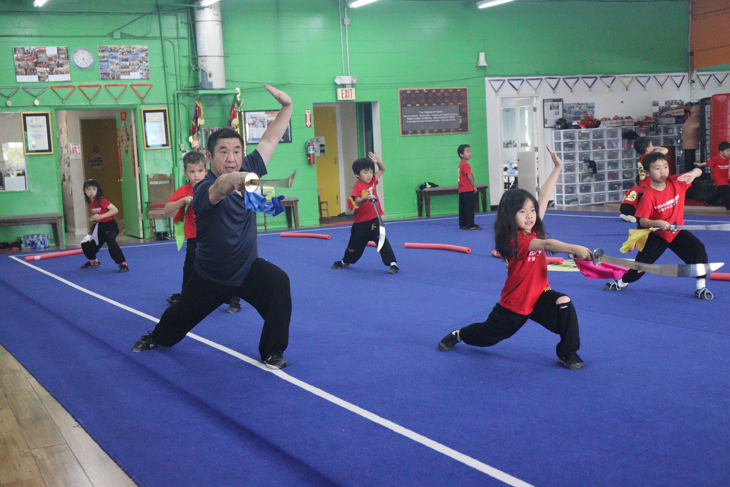 Coach and children in bow stance with broadswords